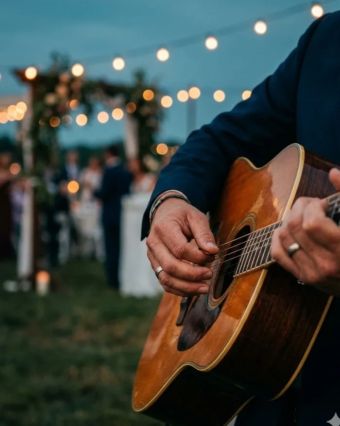 Hände an einer Akustikgitarre in der Abenddämmerung